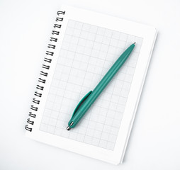 Top view of a light blue colored pen placed on top of a simple open white paper diary