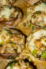 Mushrooms baked in the oven with cheese, green onions and dill. Close up.