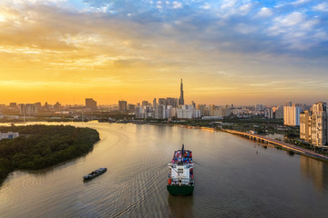 Naklejka premium Aerial view of center Ho Chi Minh City, Vietnam with development buildings, transportation, energy power infrastructure. View from the Saigon river with ships on the river. 