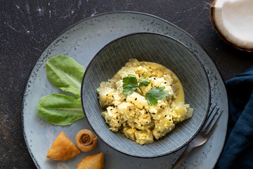 Oriental food - traditional Indian vegetarian dish of Bottle Gourd vegetable or Doodhi called Lauki Sabji. indian cuisine. Indian coconut Curry with ingredients in black background close-up, top view.