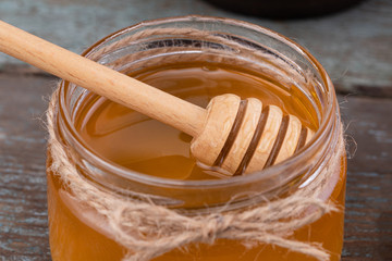  Fresh honey in the pot on a wooden background