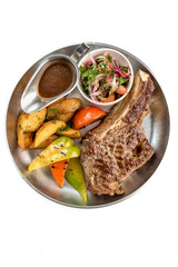 steak with vegetables in a plate on a white background isolate