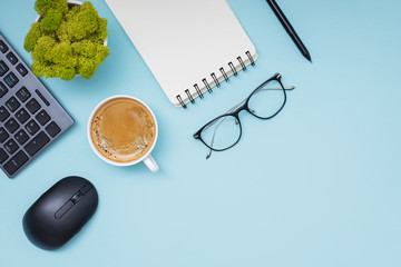Flat lay with coffee, keyboard, empty paper notepad and other office related objects