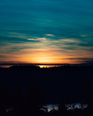 Sunset over a lake in the woods.