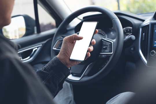 Man using smartphone inside car