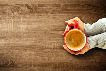 Fresh hot coffee in woman hands and wooden table of free space for your decoration. 