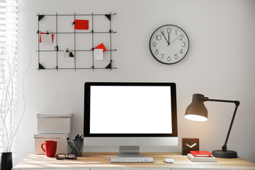 Modern computer with blank screen on table in room. Space for design