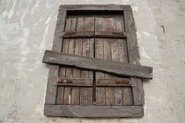 brown boarded up wooden window shutters in abandoned village house, deserted villages, poverty concept 