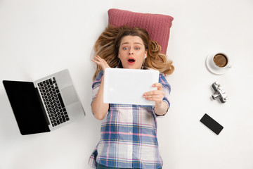 Young caucasian woman using devices, gadgets isolated on white studio background. Concept of modern...