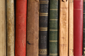 Composition of old books, with yellowed and ruined pages. Light background.