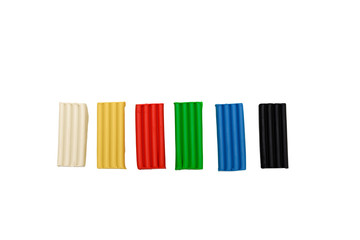 plasticine lies in a row white, yellow, red, green, blue, black, sculpt, sculpture, modeling clay top view isolate white background