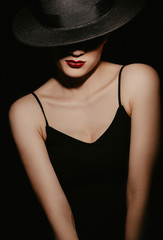 portrait of a beautiful girl in a black hat and dress