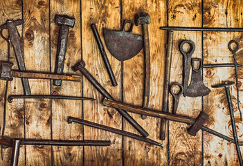 rudimentary gold mining tools hanging on a wall of planks