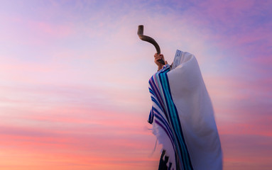 Blowing the Shofar - man in a tallith, Jewish prayer shawl is blowing the shofar ram's horn - obrazy, fototapety, plakaty