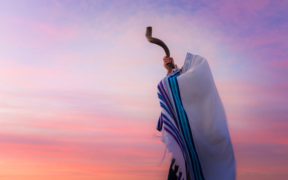 Blowing the Shofar - man in a tallith, Jewish prayer shawl is blowing the shofar ram's horn
