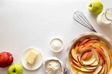 Fototapeta na wymiar Ingredients for making apple cake. Flour, sugar, butter, milk and fresh apples on white wooden background. Top view. Flat lay
