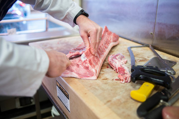 Butcher preparing pork chops on a butcher's block