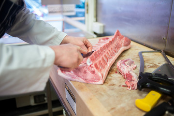 Butcher preparing pork chops on a butcher's block