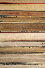 Composition of old books, with yellowed and ruined pages. Light background.