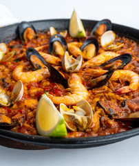 Fish and seafood paella on a white background