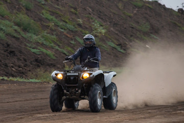 The quad racer is riding on the dirt road. Quad bike off-road. Quad bike in action © rostovdriver