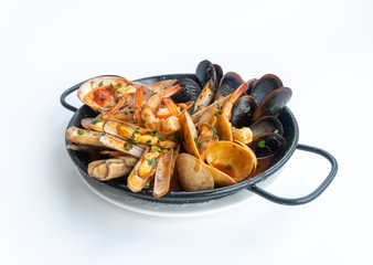 Sauteed shellfish and seafood in a black pan on a white background 