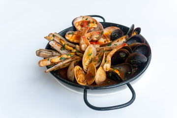 Sauteed shellfish and seafood in a black pan on a white background 