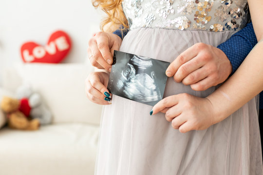 Pregnant Woman In A Dress Holding A Sonogram