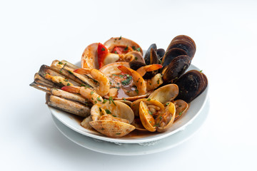 Sauteed shellfish and seafood in a white plate on a white background