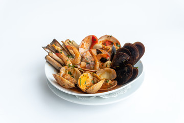 Sauteed shellfish and seafood in a white plate on a white background