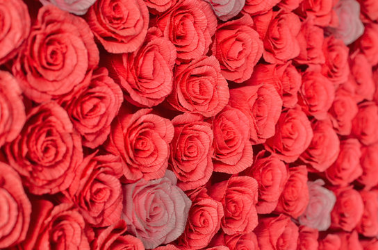 Many red and pink decorative roses background. Selective focus.