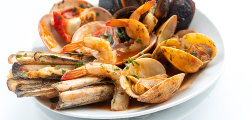 Sauteed shellfish and seafood in a white plate on a white background