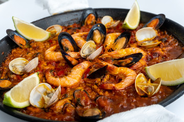 Fish and seafood paella on a white background
