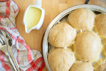 Traditional fresh bavarian yeast dumplings, vegan version, served with vanilla sauce in a pan