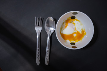 Soft-boiled eggs break when poured into a small white cup.Prepare to serve with a spoon