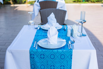 Cozy restaurant table setting in blue style with sea view