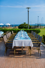 Cozy restaurant table setting in blue style with sea view