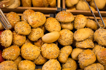 different fresh bread on the shelves in bakery.