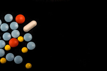 Different colorful pills on black background.Tablets on a black background. Pills. Medicine and healthy. Close up of capsules. Different kind of medicine