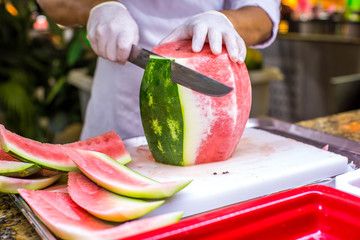 Chef cutting a delicious sweet watermelon
