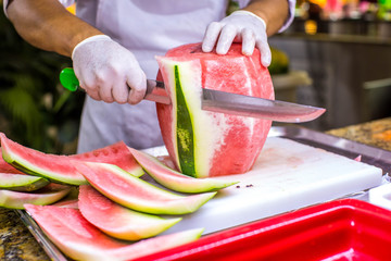 Chef cutting a delicious sweet watermelon