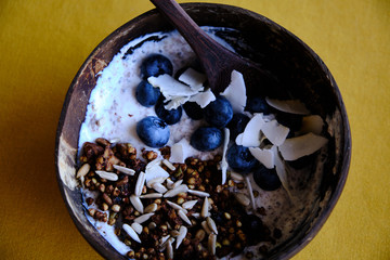 Healthy snack, yoghurt with blueberries, coconut, granola and seeds