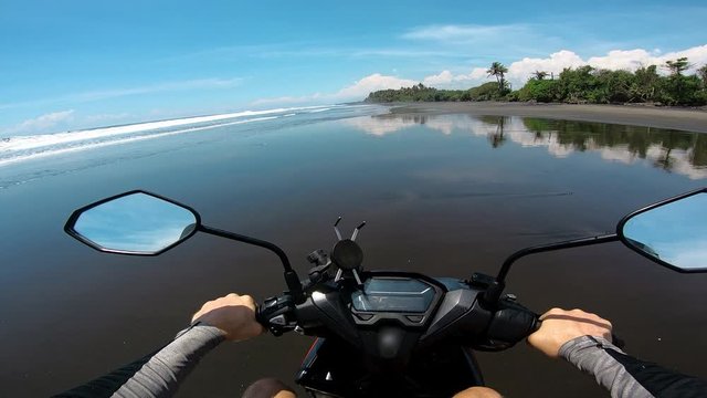 Riding a motorcycle on the sand along the sea