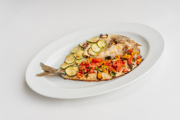 Baked fish with vegetables, zucchini and tomatoes
