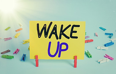 Conceptual hand writing showing Wake Up. Concept meaning an instance of a demonstrating waking up or being woken up Rise up Colored clothespin rectangle shaped paper blue background