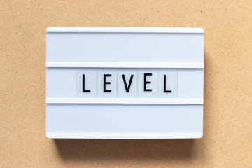 White lightbox with word level on wood background