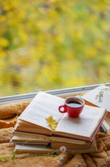 Naklejka na ściany i meble Hot coffee in the background of a window and autumn nature.