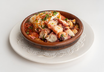 Octopus ratatouille with an egg in a clay pot dish with a white background