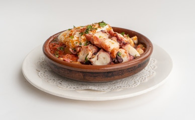 Octopus ratatouille with an egg in a clay pot dish with a white background