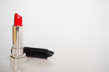 Red and black lipsticks stand on a white background: beauty salon concept, fashion